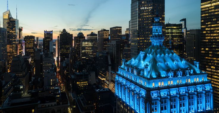 Photo of the Helmsley Building lit up blue in honor of essential workers (via RXR Realty)