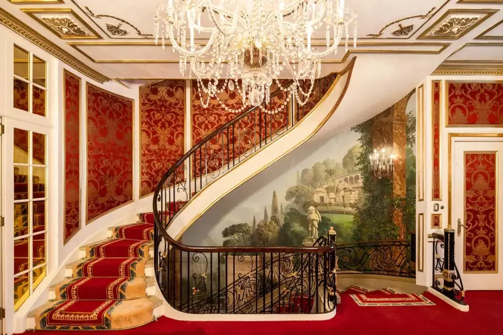 Foyer with red carpet and chandelier