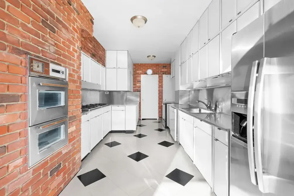 Chef's kitchen with exposed brick