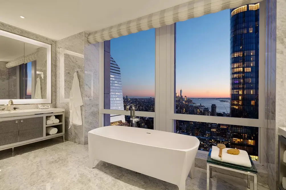 Primary bath with separate soaking tub overlooking river and skyline views