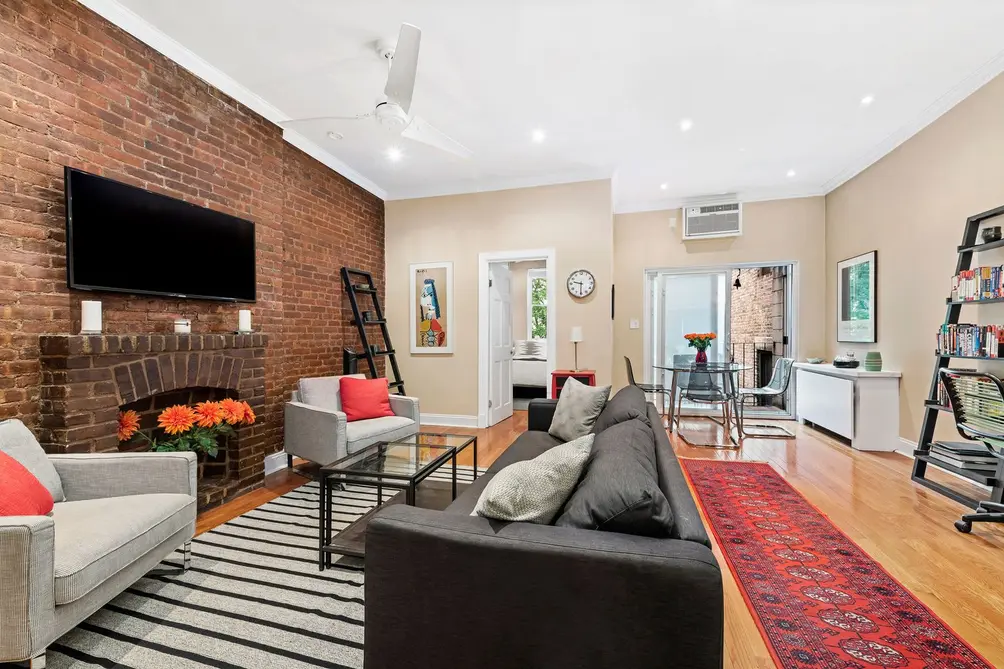 Living room with exposed brick wall and balcony access