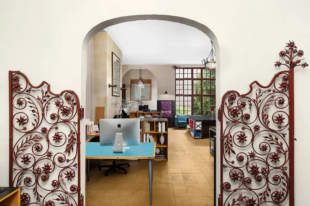 Studio with arched entryway and wrought iron gate