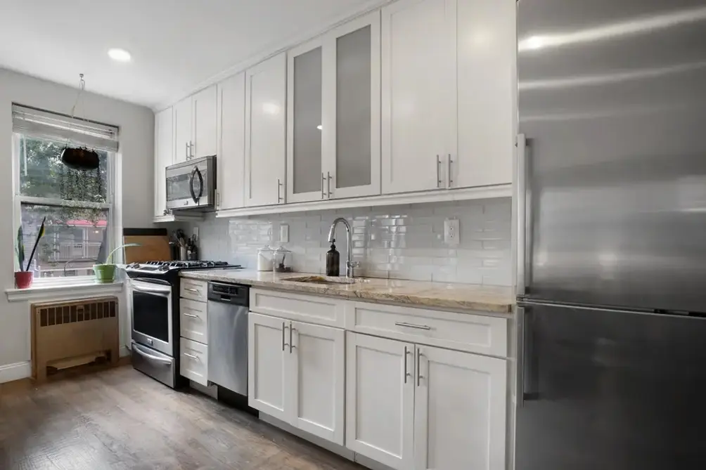 Open, windowed kitchen with stainless steel appliances