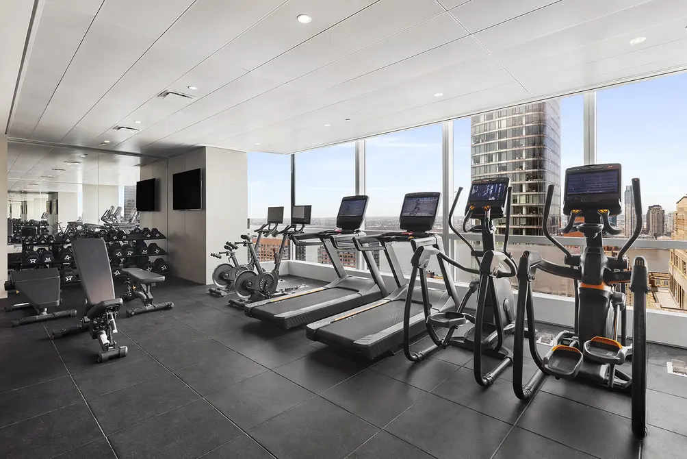 Upper-level fitness center with city and river views