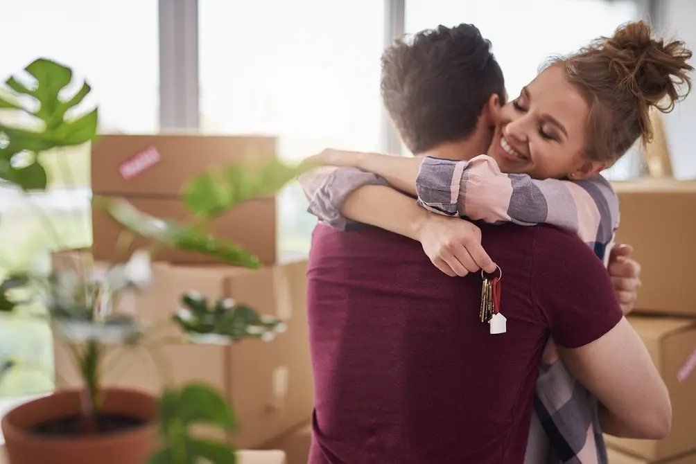 Couple embraces surrounded by boxes