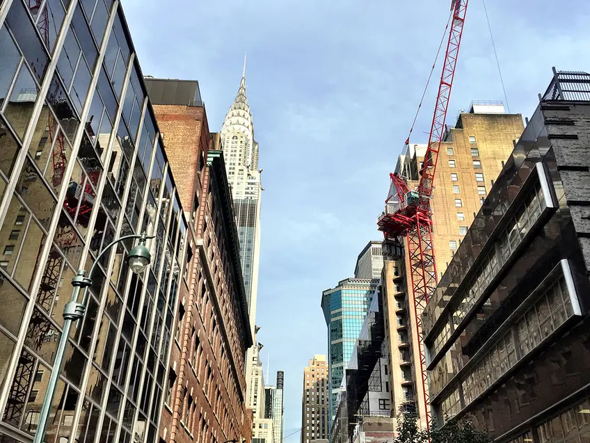Photo looking down East 43rd Street, with the crane of  222 East 44th on the left